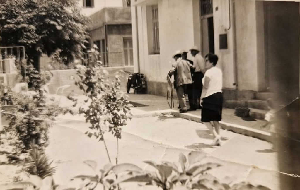 Παλαιότερη εξωτερική φωτογραφία με ανθρώπους κοντά στην είσοδο.
